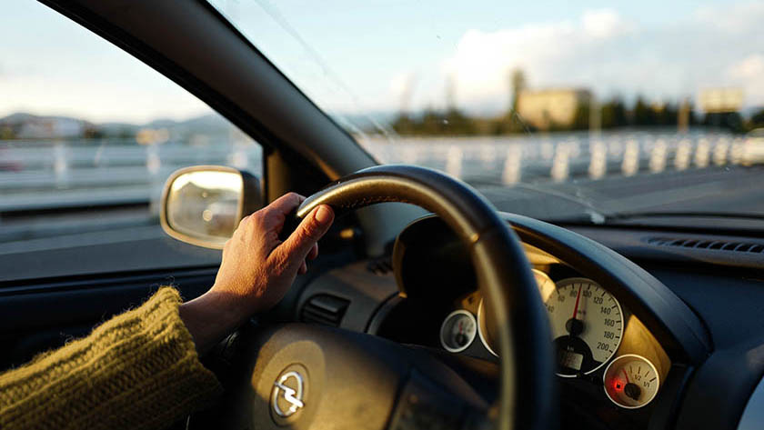 Close up of a hand on a car steering wheel